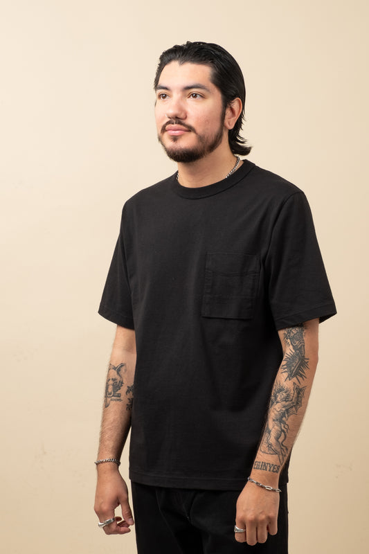 Man wearing a black t-shirt against a beige background