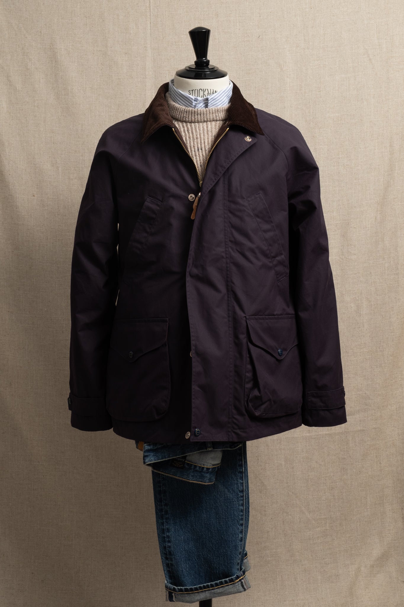 Dark jacket on a mannequin with a plain background